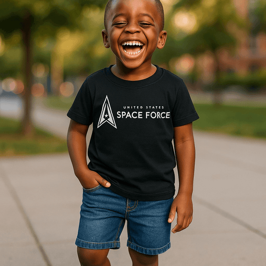 Toddler wearing a black T-Shirt with United States Space Force logo, smiling outdoors.