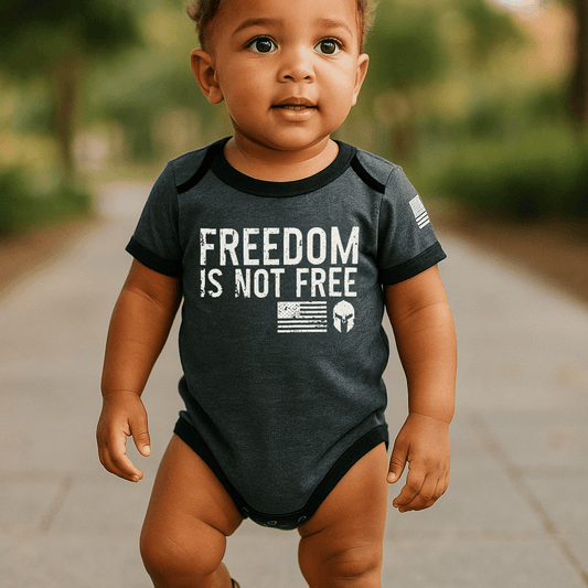 Baby wearing a graphite gray bodysuit with "Freedom Is Not Free" print and American flag on the sleeve.