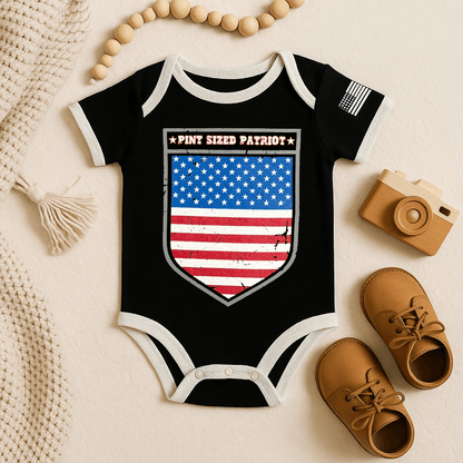 Baby bodysuit featuring distressed American Flag shield and text 'PINT SIZED PATRIOT' on a black background.