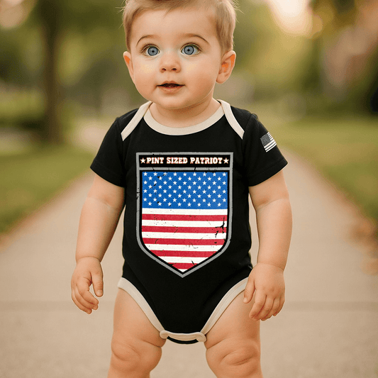 Baby wearing a Pint Sized Patriot bodysuit with American flag design outdoors.