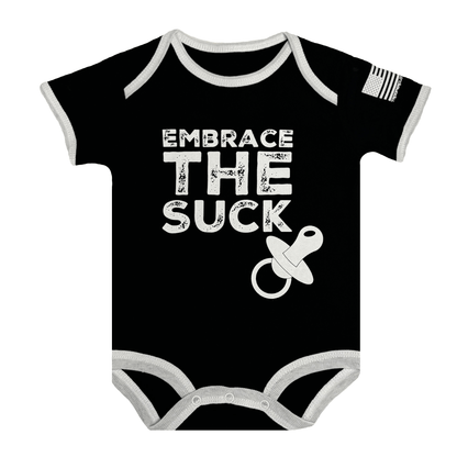 Baby bodysuit with black fabric, white text saying 'Embrace The Suck' and American flag sleeve.