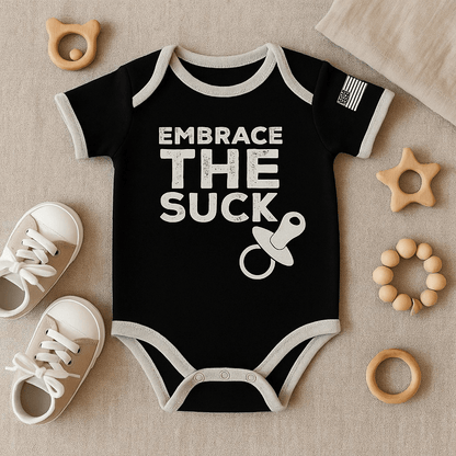 Baby Embrace the Suck bodysuit in black with American flag and pacifier design on a soft background.