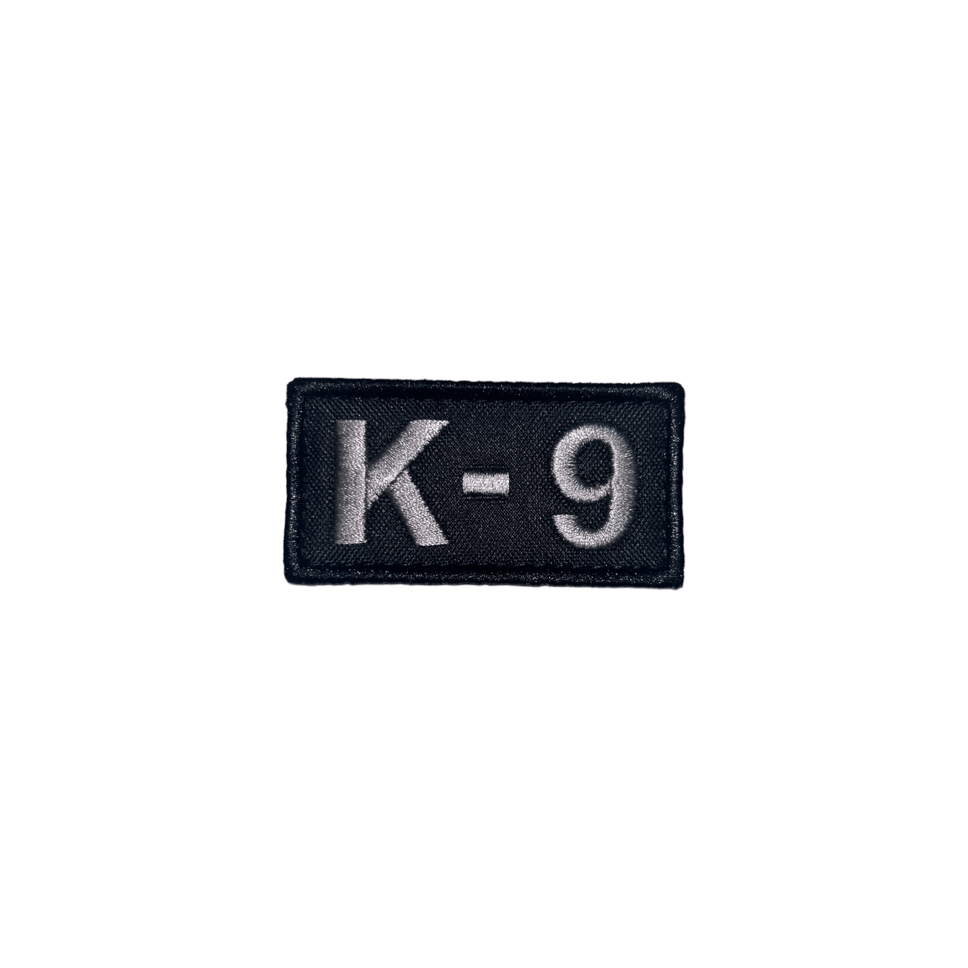 Embroidered patch featuring 'K-9' in light gray, perfect for dog vests, dimensions 2 3/4" x 1 3/8", with hook and loop.