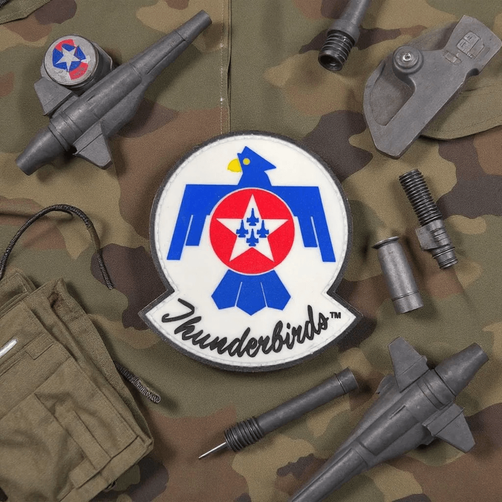 Patch Thunderbirds PVC on camouflage fabric with military accessories, perfect for adding to your gear.
