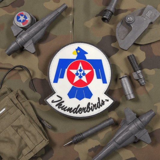 Patch Thunderbirds PVC on camouflage fabric with military accessories, perfect for adding to your gear.
