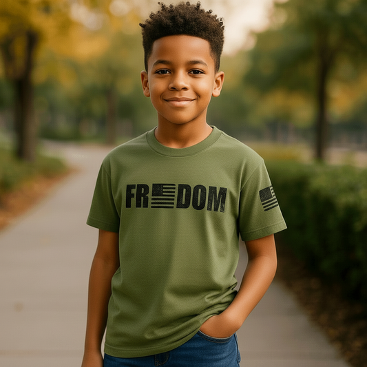 A young boy wearing a Trooper Clothing OD green performance T-shirt with a Freedom flag graphic and sleeve logo.